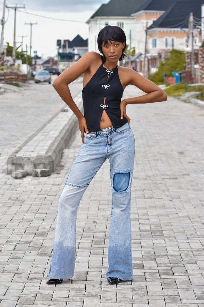 Fashionable woman in trendy outfit poses confidently on urban street.
